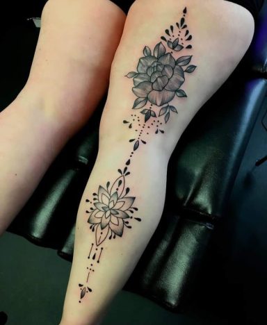 Detailed floral tattoo design on the calf, featuring roses and ornamental elements.