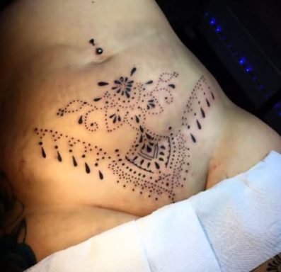 Intricate black henna tattoo on the shoulder, featuring floral and geometric designs.