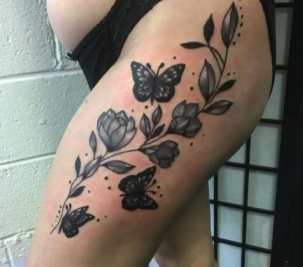 Tattoo design featuring butterflies and flowers on a thigh.