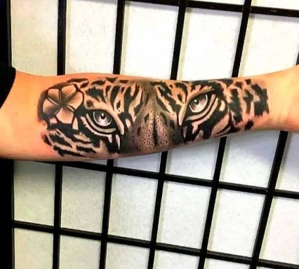 A detailed tattoo of a tiger's face on a forearm.