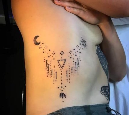 Side tattoo featuring geometric shapes, celestial symbols, and decorative elements.